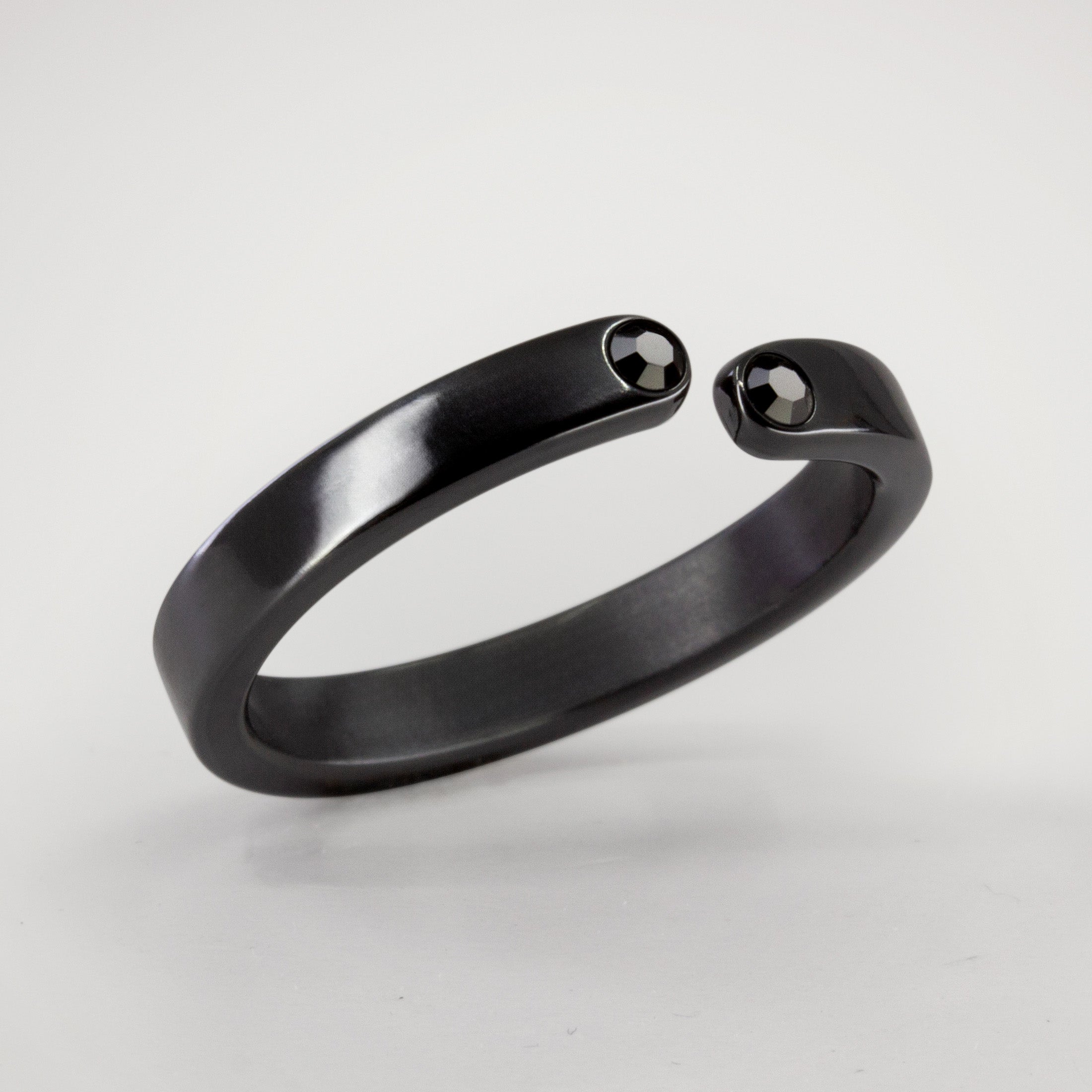 Split zirconium flat ring with 2 black crystals
